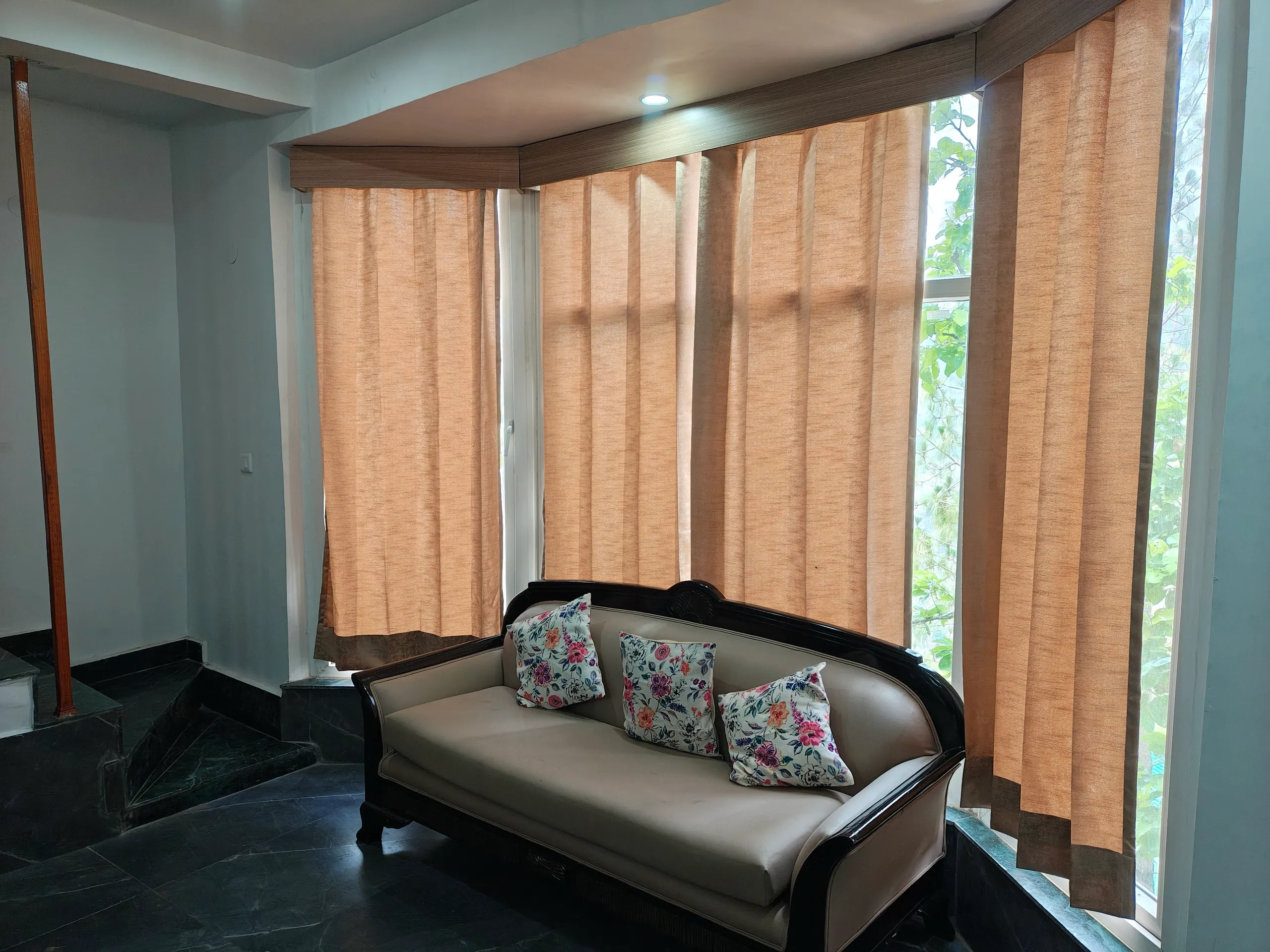Sofa in living room bay window with curtains drawn