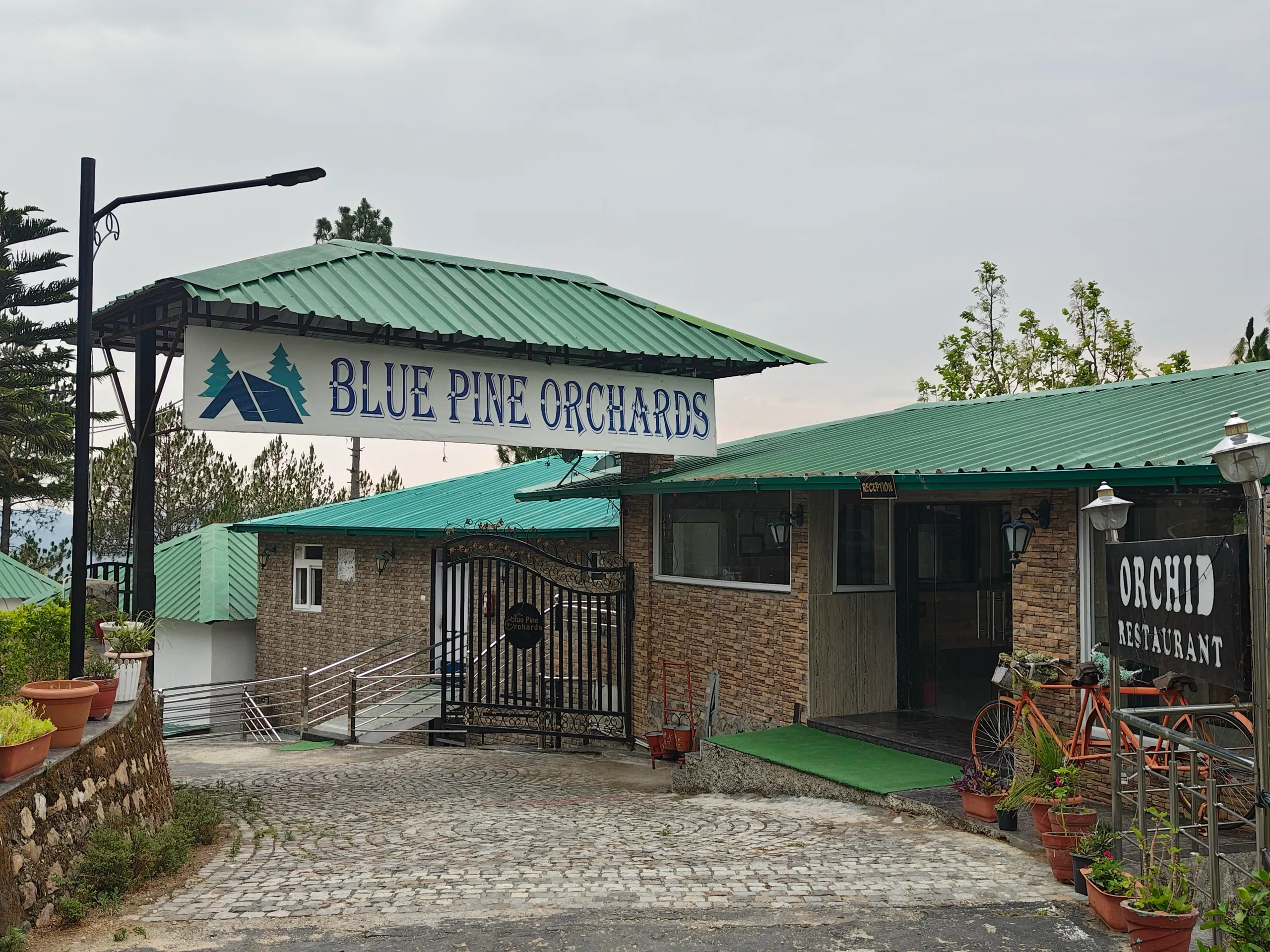 Blue Pine Orchards resort entrance gate with Orchid Restaurant signboard
