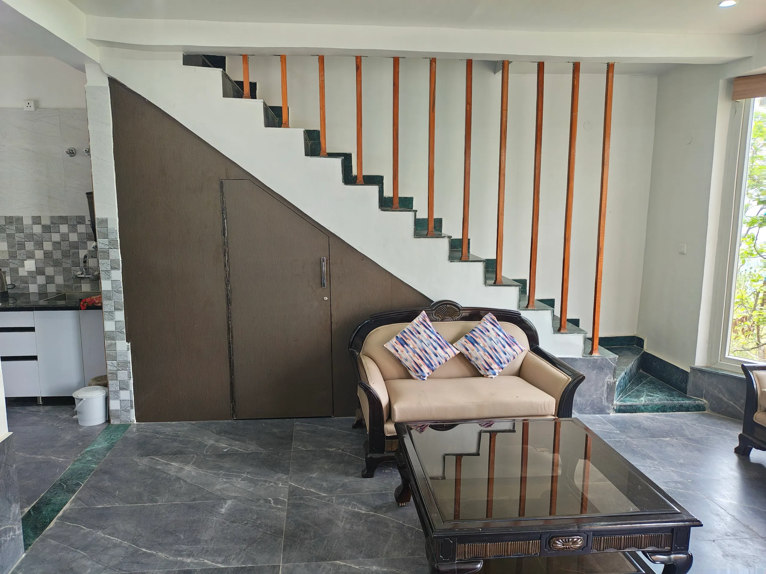 Staircase leading up to the second floor with kitchen alongside